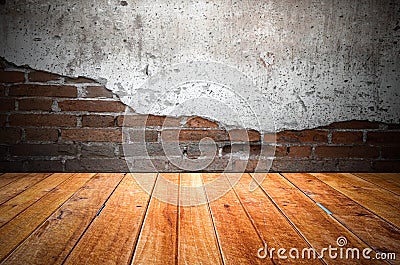 Grungy textured red brick and stone wall with warm brown wooden floor inside old neglected and deserted interior, masonry and carp Stock Photo