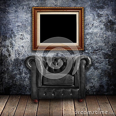 Grungy wall with Classic Brown leather armchair and gold frames Stock Photo