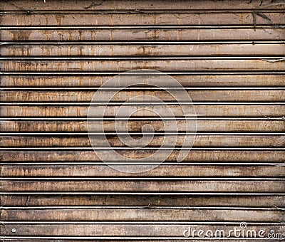 Grungy weathered metallic roll up door. Rusty iron gate. Stock Photo