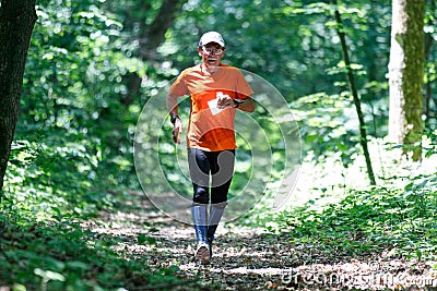 GRUNIVKA, SUMY REGION, UKRAINE - JUNE 21, 2021: Sportsman running through the forest on the race of SKIF Cup XIV sports Editorial Stock Photo