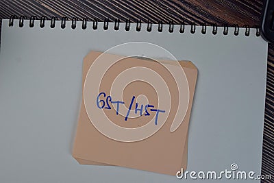 GST or HST write on sticky notes isolated on Wooden Table Stock Photo