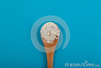 Guar gum powder or guaran in wooden spoon. Food additive E412. Guar Gum is extracted from the seed endosperm of the plant called Stock Photo