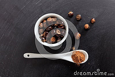 Guarana seeds and powder in porcelain bowl and spoon Stock Photo