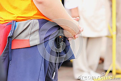 guard in civilian clothes and a walkie-talkie on his belt keeps order among the crowd of people Stock Photo