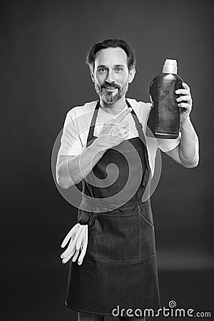 On guard of cleanliness and order. Cleaning service and household duty. Man in apron with gloves hold plastic bottle Stock Photo