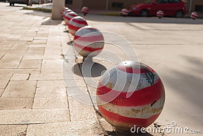 Guardamar del Segura, Alicante, Spain; December 8 2.017: Red and white bollards on stone sidewalk Editorial Stock Photo