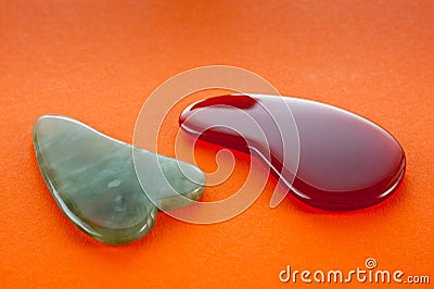 Guasha scrapers for body massage according to the ancient method shot on a bright red background Stock Photo