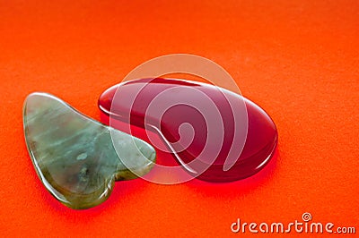 Guasha scrapers for body massage according to the ancient method shot on a bright red background Stock Photo