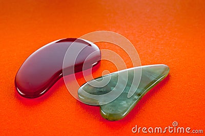 Guasha scrapers for body massage according to the ancient method shot on a bright red background Stock Photo