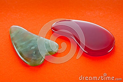 Guasha scrapers for body massage according to the ancient method shot on a bright red background Stock Photo