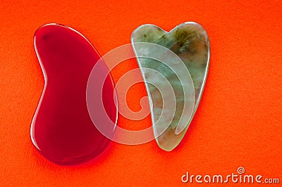 Guasha scrapers for body massage according to the ancient method shot on a bright red background Stock Photo