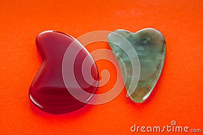 Guasha scrapers for body massage according to the ancient method shot on a bright red background Stock Photo