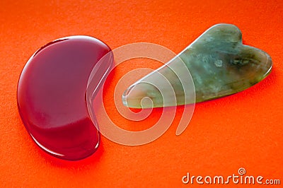 Guasha scrapers for body massage according to the ancient method shot on a bright red background Stock Photo