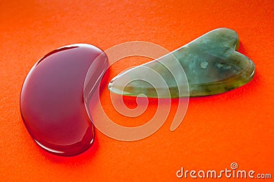 Guasha scrapers for body massage according to the ancient method shot on a bright red background Stock Photo