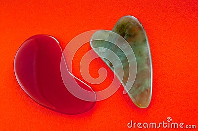 Guasha scrapers for body massage according to the ancient method shot on a bright red background Stock Photo