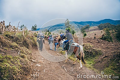 GUATEMALA - January 08: Group of hikers at the Acatenango Volcano are passed by two locals on horse back, January 08, 2017 near Editorial Stock Photo
