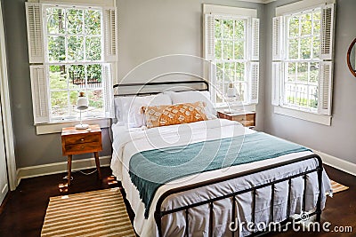 A guest bedroom with a queen sized bed and nightstand at a short term rental small cottage style house Stock Photo