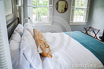 A guest bedroom with a queen sized bed and nightstand at a short term rental small cottage style house Stock Photo