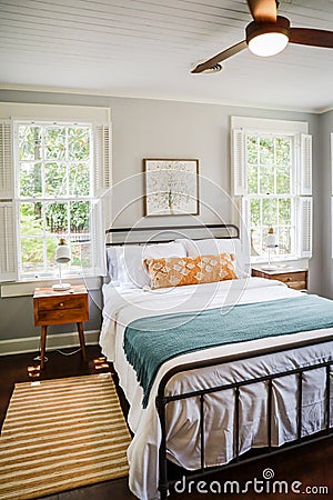 A guest bedroom with a queen sized bed and nightstand at a short term rental small cottage style house Stock Photo