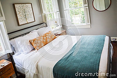 A guest bedroom with a queen sized bed and nightstand at a short term rental small cottage style house Stock Photo