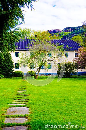 Guest House with Green Lawn and Rocky Path, Norway Stock Photo