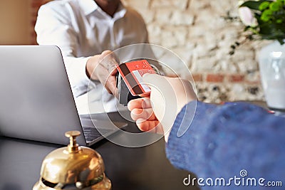 Guest makes card payment at check-in desk of hotel, detail Stock Photo