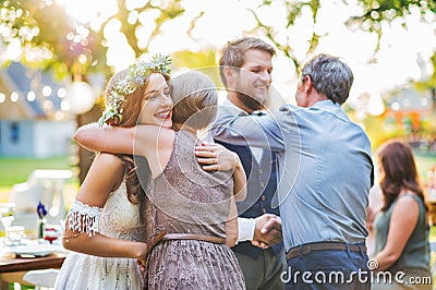 Guests congratulating bride and groom at wedding reception outside in the backyard. Stock Photo