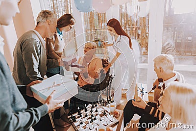 Guests Give Gifts to Elderly Woman.Birthday Party. Stock Photo