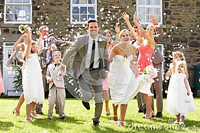 Guests Throwing Confetti Over Bride And Groom Stock Photo