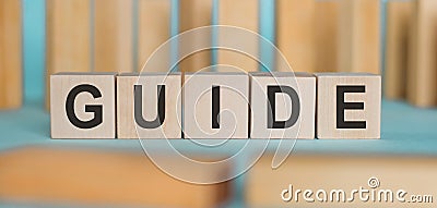 GUIDE word concept written on a wooden cubes on a blue table Stock Photo