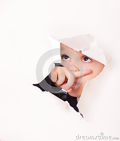 Guilty looking kid in a hole in white paper Stock Photo