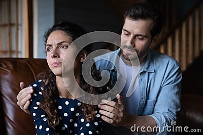 Guilty young husband hug shoulders of offended wife ask forgiveness Stock Photo