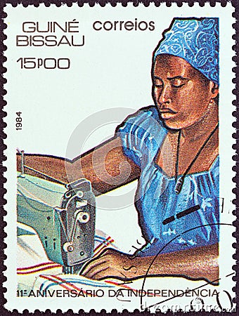 GUINEA-BISSAU - CIRCA 1984: A stamp printed in Guinea-Bissau shows woman sewing, circa 1984. Editorial Stock Photo