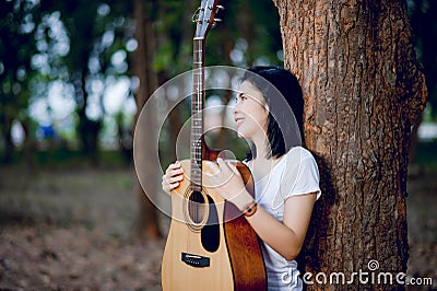 Guitar Happily hug the guitar, standing in the woods, open air, fresh music Stock Photo