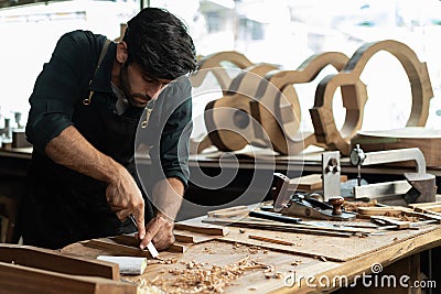 guitar luthier using chisel to shave bracing of acoustic guitar Stock Photo
