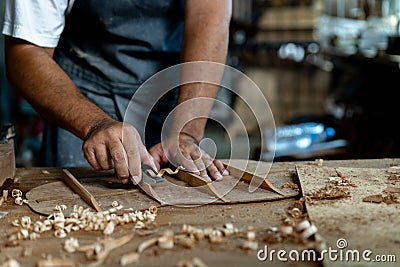 Guitar luthier using small planer to fine-tune bracing of acoustic guitar Stock Photo