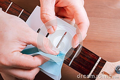 Guitar master polishing frets of electric guitar with template, top view Stock Photo