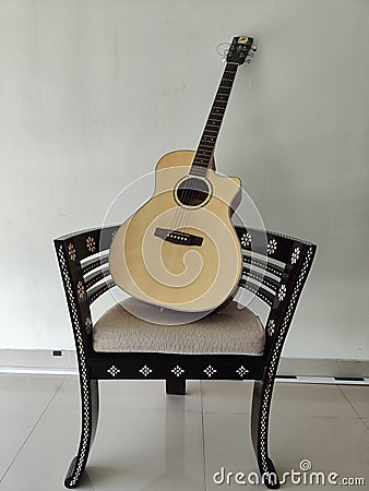 a guitar and a matching pair chair accompany the break Stock Photo