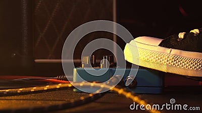 Guitar pedals and footswitch inside recording room. Close up of guitar pedals and musician`s foot tapping on it for Stock Photo