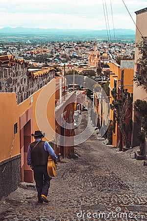 A Mexican guitar player walks on the streets of San Miguel de Allende Stock Photo