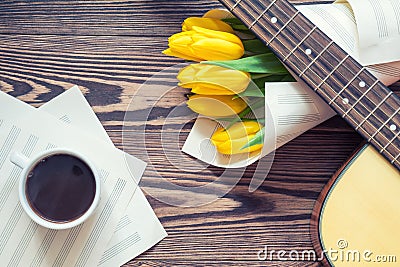 Guitar, yellow tulips, cup of coffee, musical page Stock Photo