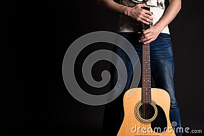 Guitarist holding two hands with an acoustic guitar on a black isolated background Stock Photo