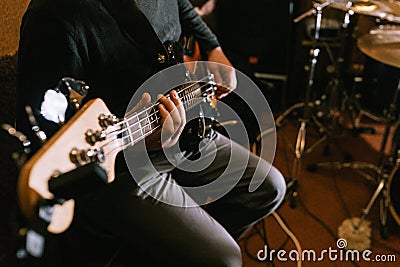 Guitarist playing bass guitar in studio closeup Stock Photo