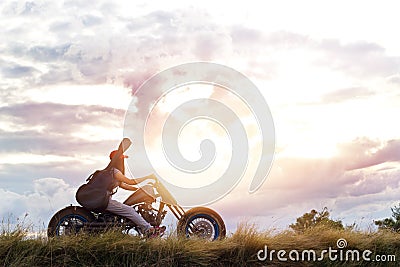 Guitarist woman riding a motorcycle on the countryside road Stock Photo