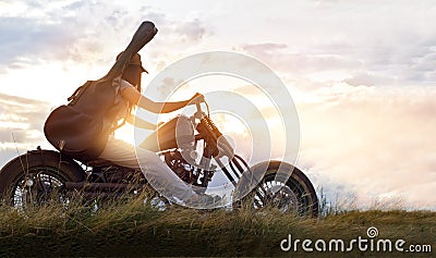 Guitarist woman riding a motorcycle on the countryside road Stock Photo