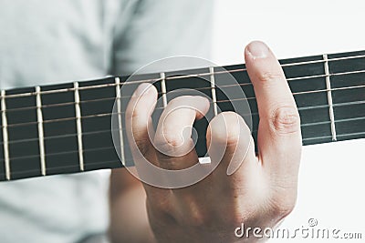 Guitarists hand playing an major barre chord on the fretboard of an classical guitar Stock Photo
