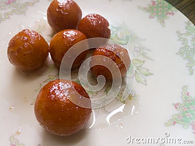 Gulab jamun balls with sugar syrup placed in a white plate. Stock Photo