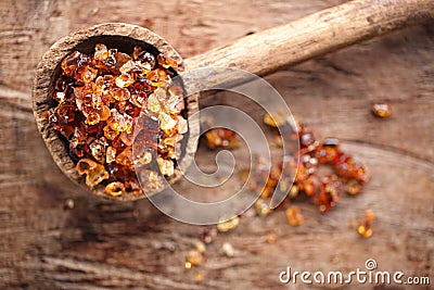 Gum arabic, also known as acacia gum - in old wooden spoon Stock Photo