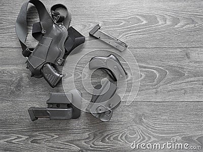 Gun black, spare magazines and leather holster on grey background. Stock Photo