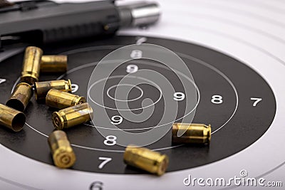 Gun and bullets on bull eye target for shooting practice Stock Photo